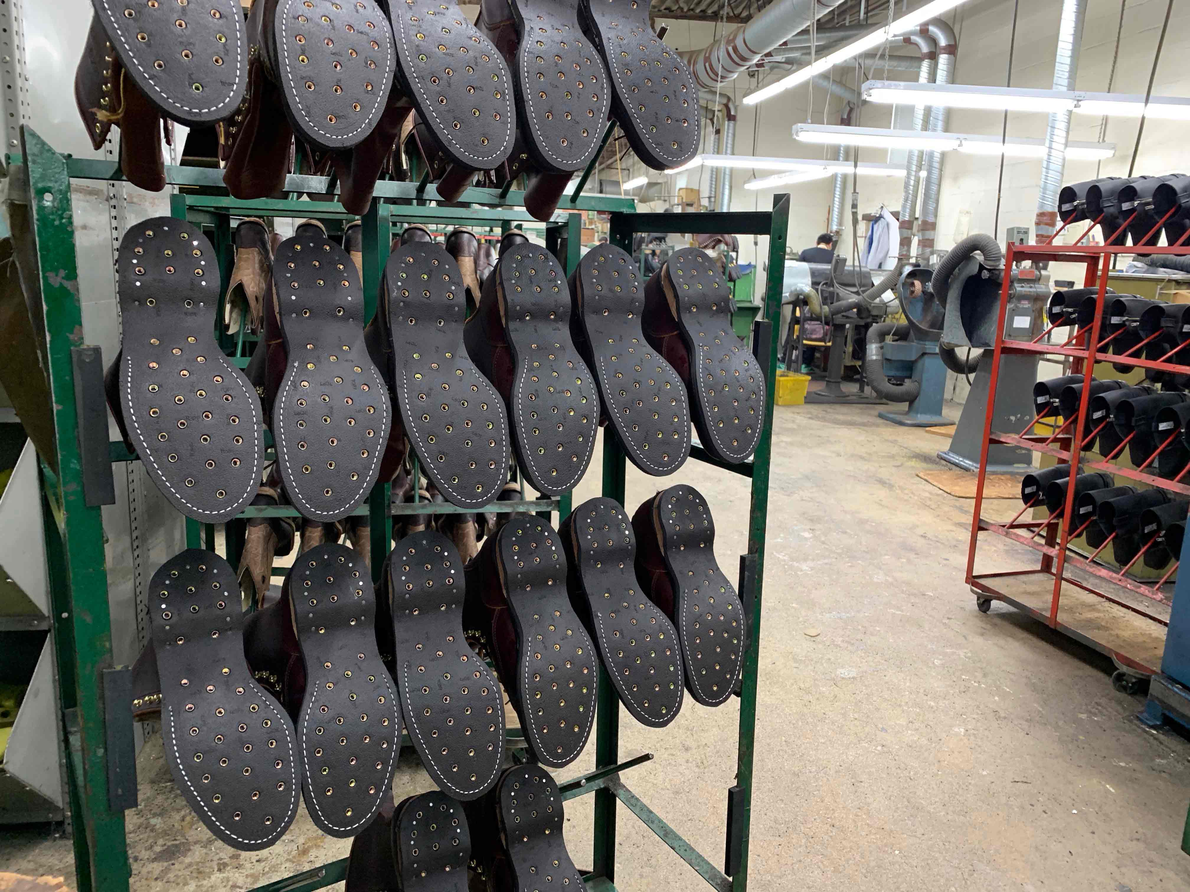 The shoes sit on racks, waiting for the next stage of the process.