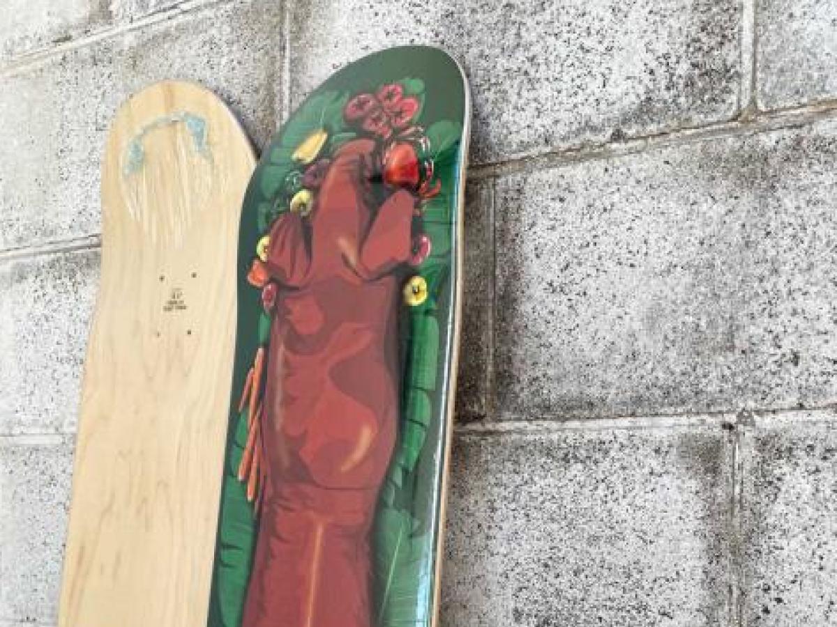 Lechon Skateboard leaning against wall