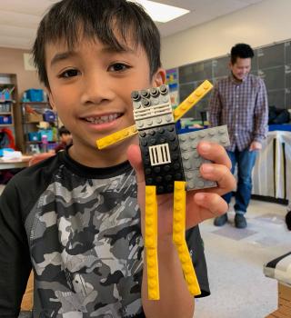 Milaño holds up his LEGO Superhero